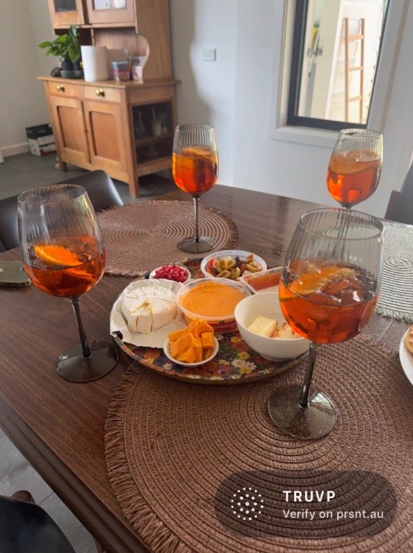 A shared Present photo of drinks on a table, with its code and Verify on prsnt.au stamped in the corner